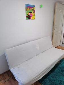 Una cama en una habitación con una sábana blanca. en Small low cost Dorcol, en Belgrado