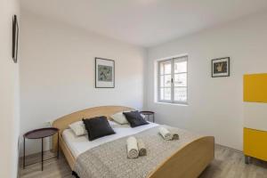 um quarto com uma cama com almofadas pretas e brancas em Hvar Bayfront em Hvar