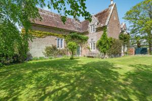 an old brick house with a large yard at The Old School Cottage in Woodsford