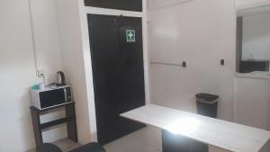 a room with a black door and a table and a microwave at ROOMS for rent in Mexico City +14 photos