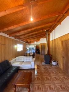 a living room with a couch and a table at Cabaña en el Campo de Villarrica in Huiscapi