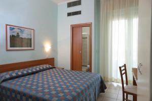 a hotel room with a bed and a bathroom at Hotel Iones in Rimini