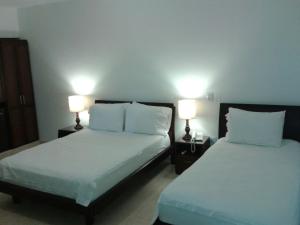two beds in a room with two lamps on them at Hotel Palonegro in Bucaramanga +47 photos