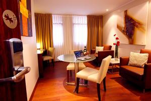 Hotel Reina Isabel في كيتو: غرفة معيشة مع طاولة مع لاب توب عليها