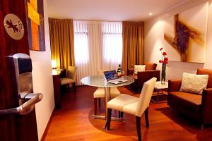 a living room with a table with a laptop on it at Hotel Reina Isabel in Quito