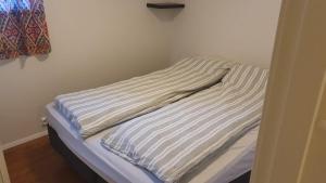 a unmade bed in a corner of a room at Cozy apartment with free parking and barbecue area in Tromsø