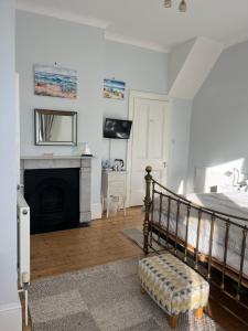 a bedroom with a bed and a fireplace at Cliftonville House in Whitstable