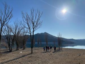 a group of people walking on a beach near a lake at CAL JOAN pallars in Salás de Pallás