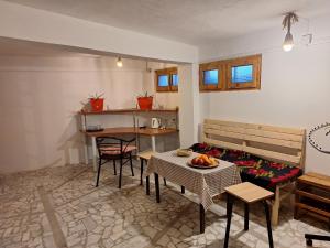 a living room with a table and chairs and a kitchen at At Pikotiko's - Korca City Rooms for Rent in Korçë