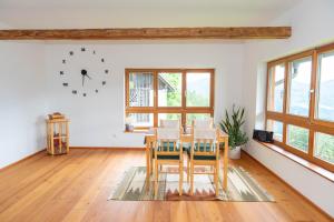 a dining room with a table and a clock on the wall at Ferienhaus Sonnseitn in Greifenburg