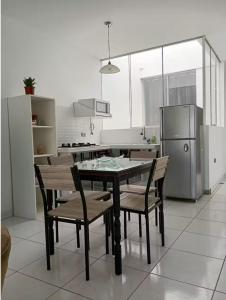 a kitchen with a table and chairs and a refrigerator at Lugar encantador junto al mar in Pacasmayo