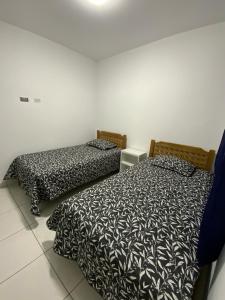 two beds sitting next to each other in a room at Lugar encantador junto al mar in Pacasmayo
