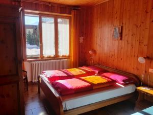 a bedroom with a bed with red and yellow blankets at Appartamenti Via Monte Braulio 19 in Bormio