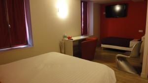 a bedroom with a bed and a chair and a tv at Hôtel Restaurant Carpe Diem CLIMATISE in Savigneux