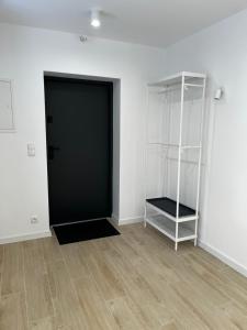 an empty room with a black door and a shelf at Apartamenty pod sosną in Zakrzewo