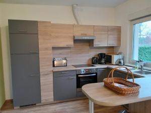 a kitchen with gray cabinets and a table with a basket at Ferienbungalow Kräuterhexxe in Brandenburg an der Havel