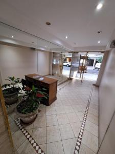an empty lobby with a piano and potted plants at Apartamento moderno en Las Cañitas, Palermo in Buenos Aires