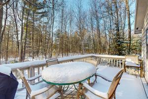 a table and chairs on a balcony with snow on it at Dani’s Trailside Escape in Manitowish Waters