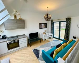 a living room with a blue couch and a table at 3 The Salt Yard, Whitstable - free parking, centre of town, 2 min walk to beach in Whitstable