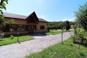 a house with a stone driveway in front of it at GreenMoodHouse in Comăneşti