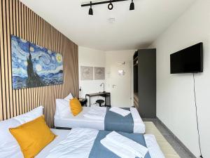 a hotel room with two beds and a tv at LTA Apartment München Süd No2 Relax & Chill in Munich