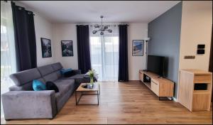 a living room with a couch and a tv at Spokojna Sosnówka in Sosnówka