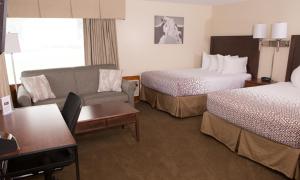 a hotel room with two beds and a couch at Knotty Pine Motel in Bennington