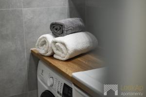 a stack of towels sitting on top of a washing machine at Diasfera Premium by LookAp in Łódź +16 photos