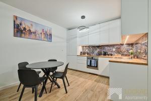 a kitchen with a table and chairs in a room at Diasfera Premium by LookAp in Łódź