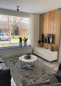 a living room with a couch and a tv and a table at Spacious house next to the mill! in Westkapelle