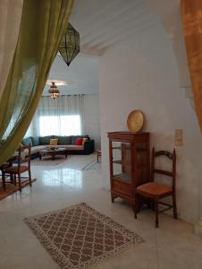 a living room with a chair and a table at Villa Azur Haouaria in Sidi Amor