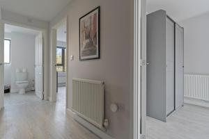 a white room with a toilet and a mirror at Exquisite 7 Bedroom 5 Bathroom House - Over 1900 sqft - Close to City Centre with Free Parking, Fast W-Fi and SmartTVs by Yoko Property in Northampton