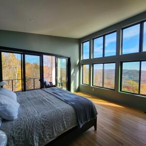 a bedroom with large windows and a bed with a view at Altitude Adjustment in Nellysford