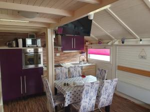 Una cocina con una mesa y sillas y un fregadero. en Spa Cottage Lavender in Terme Čatež, en Čatež ob Savi