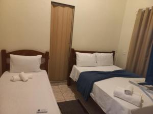 a bedroom with two beds with towels on them at Hostel X DE CARAIVA in Caraíva
