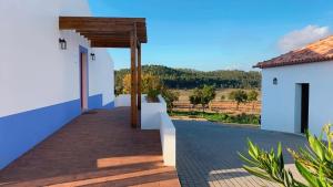 a walkway leading to a white building with a view at Monte da Caniveta - Casa dos Compadres in São Luis