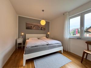 Un dormitorio con una cama y una ventana grande. en See Raum, en Immenstaad am Bodensee