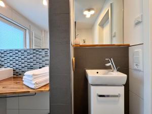 un baño con lavabo y espejo en See Raum, en Immenstaad am Bodensee