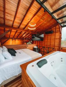 a bedroom with a bed and a bath tub at Refúgio Paraíso Casa Stellato Spa Panorâmica in Orleans