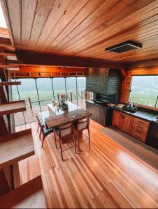 a kitchen and dining room with a table and chairs at Refúgio Paraíso Casa Stellato Spa Panorâmica in Orleans