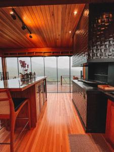 a kitchen with a counter and a large window at Refúgio Paraíso Casa Stellato Spa Panorâmica in Orleans