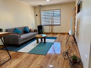 ein Wohnzimmer mit Couch und Tisch in der Unterkunft Cabaña Coyhaique in Coihaique