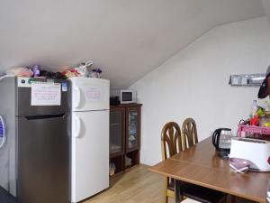 a kitchen with a white refrigerator and a table at Historia Hostel in Skopje