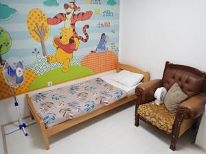 a bedroom with a bed and a couch and a wall at Historia Hostel in Skopje