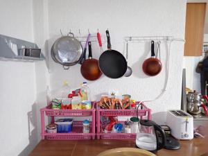 a kitchen counter with utensils hanging from a wall at Historia Hostel in Skopje