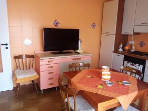 a kitchen with a table and a television on a cabinet at Holiday home Carmelo and Daniela in Porto Empedocle