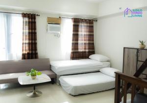a living room with two beds and a couch at Family Unit A with Balcony - Iloilo Condo Living in Iloilo City