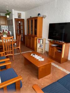 a living room with a flat screen tv and a table at Olhao Apartment in Olhão