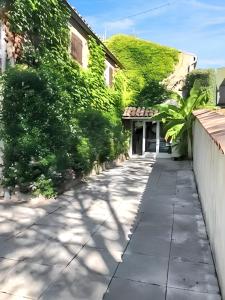 un marciapiede accanto a un edificio con edera verde di Villa spacieuse avec piscine à Rocher 180 m² 10 pers. a Rocher