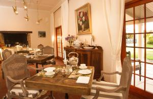uma sala de jantar com uma mesa de madeira e cadeiras em Sorgvry - House of Guests em Barrydale